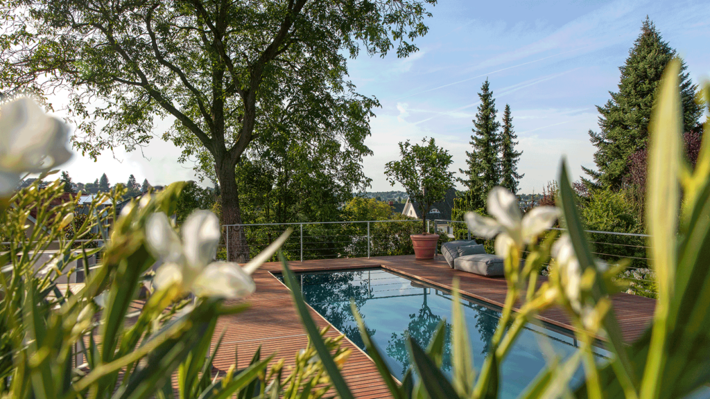 Ein Pool mit Holzterrasse und mit gutem Ausblick in die Weite. 