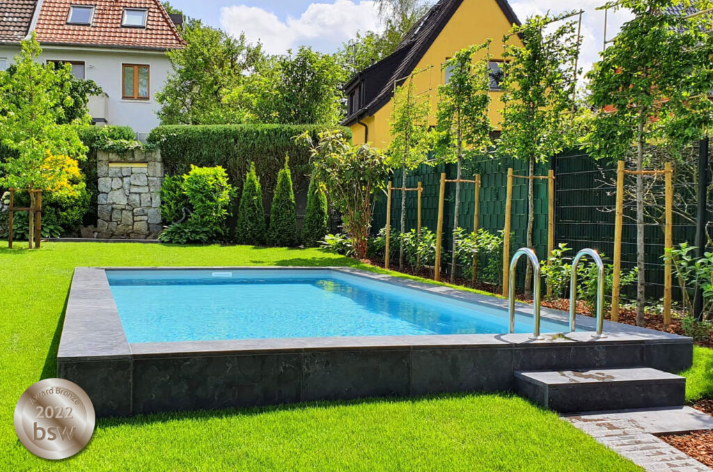 Pool im Garten mit Einstiegstreppe und Umrandung.