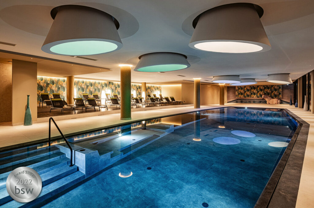 Pool im Hotel mit mehreren Wellnesszonen im Stilmix