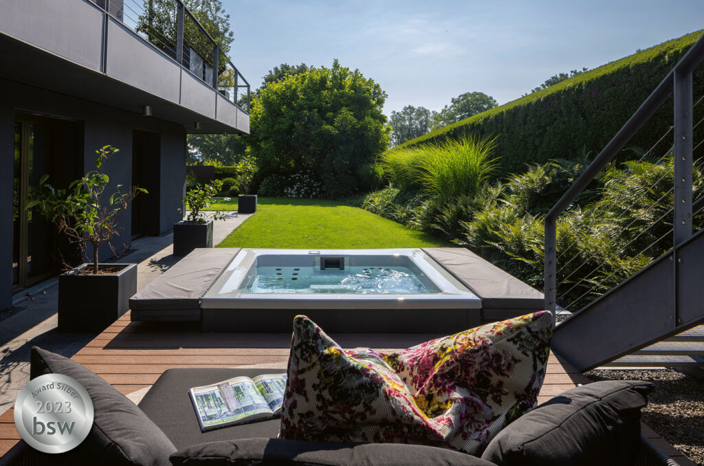 Blick Terrasssen-Lounge auf Whirlpool und grünem Garten