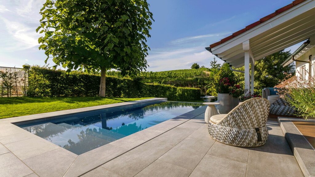 Infinity-Pool mit eleganter Terrasse und Blick in den Weinberg