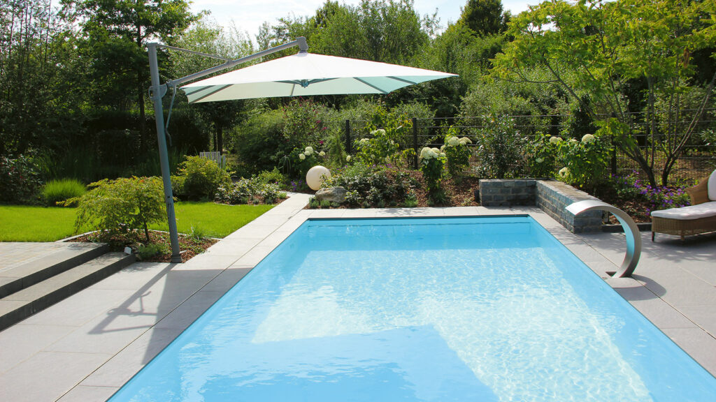 Pool mit hohem Wasserstand im Garten mit Sonnenschirm