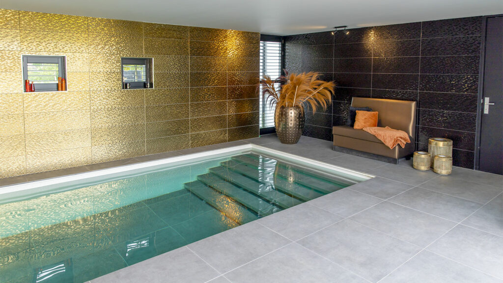 Indoorpool mit beweglichem Boden und vielen goldenen Dekorationen rundherum.